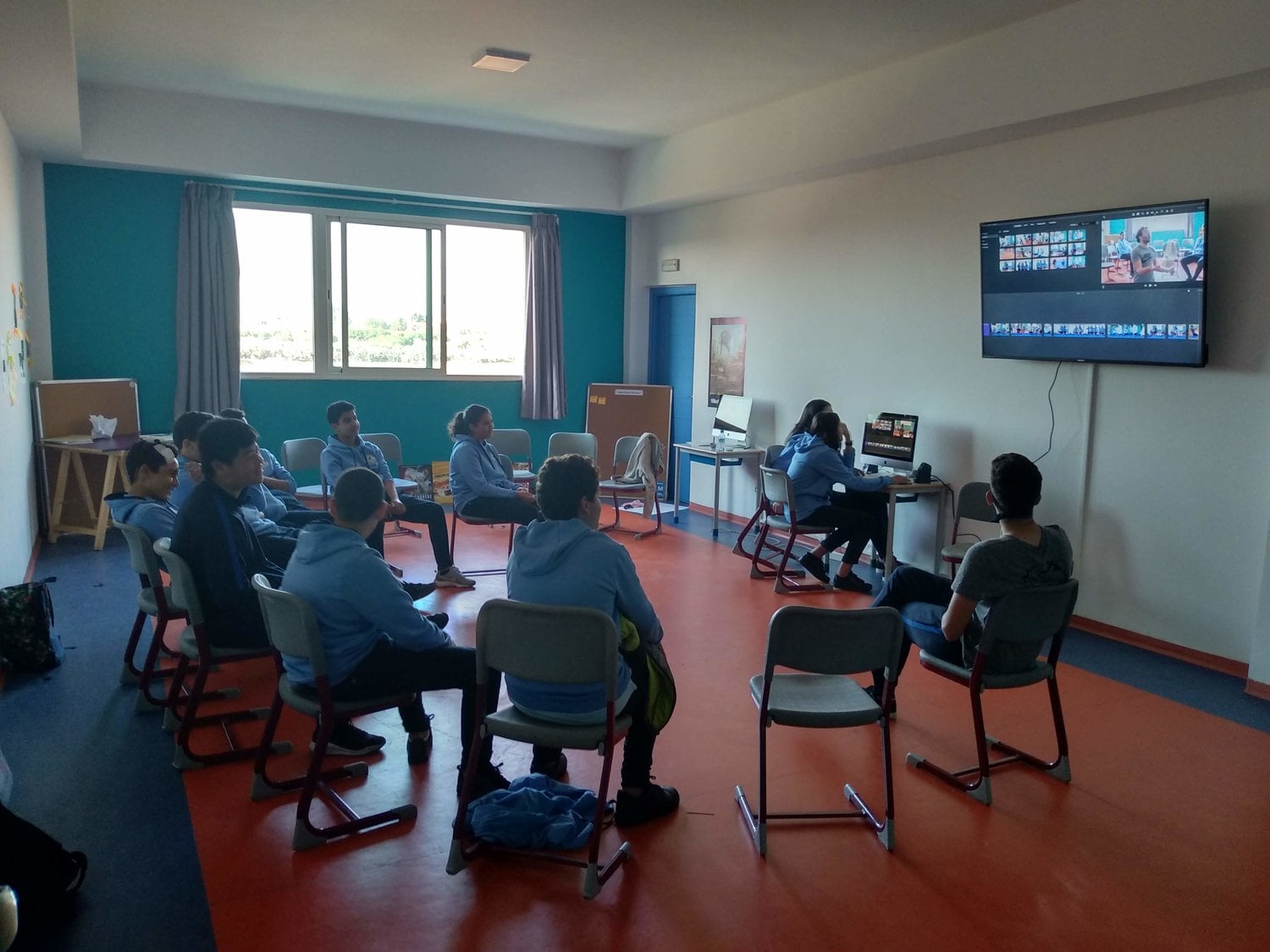 Learners reviewing a film-editing timeline together in a classroom
